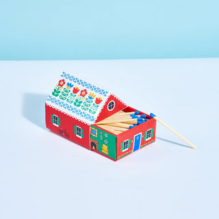 Colorful matchbox house with matches on a light blue background