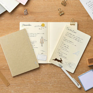 Assorted B6 2mm grid notebooks with cards and paperclips on a wooden tabletop