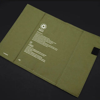 Green notebook cover with text and a logo on a black background