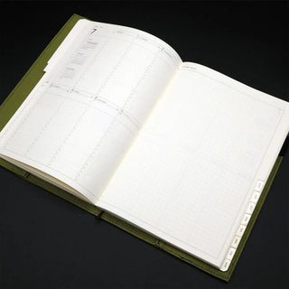 Open planner with green notebook cover on a black background