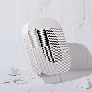 Löv air purifier with cradle stand in cream white, angled front view