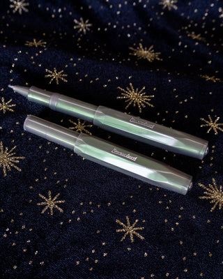 Two green Kaweco pens on a black fabric star background