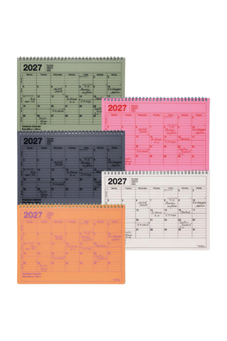Colorful monthly notebook calendars on a light background