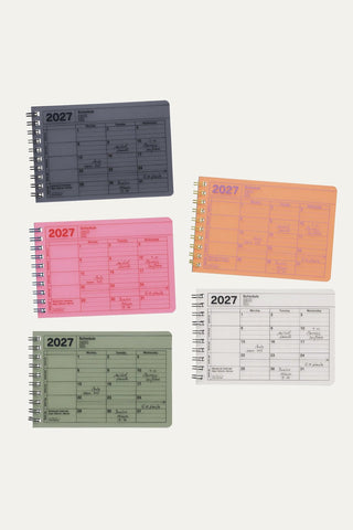 Small colorful monthly notebook calendars on a light background