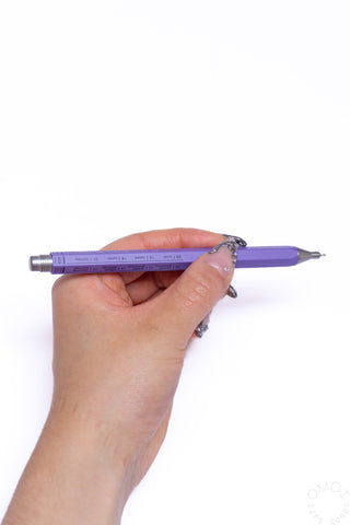 Hand holding a purple pen on a white background