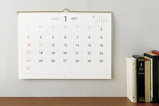 MD 2027 hanging wall calendar on wall, monthly grid with January dates.
