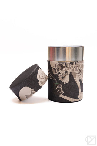 Dark tea canister with silver lid and ukiyo-e skeleton graphic; lid shown beside