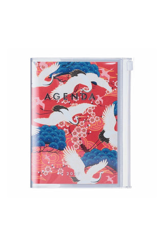 planner with cover of crane birds, flowers and other nature elements on a red background