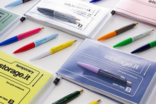 Multiple Marks mini pens and storage.it notebooks on a white background