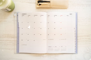 Opened planner on table showing monthly calendar for march 2027