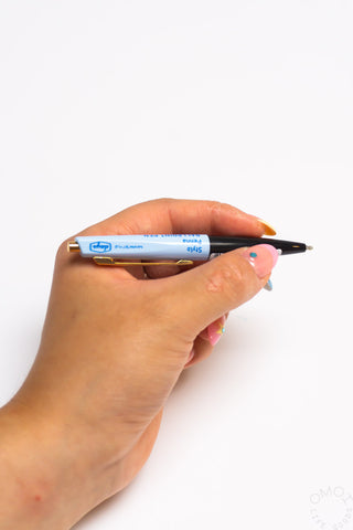 Hand holding a Marks mini pen with a white background