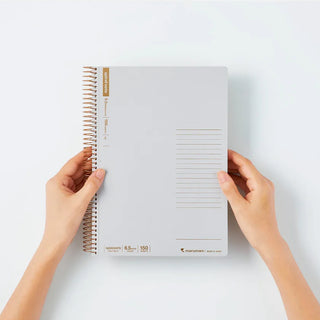 Person holding a spiral-bound notebook on a white background