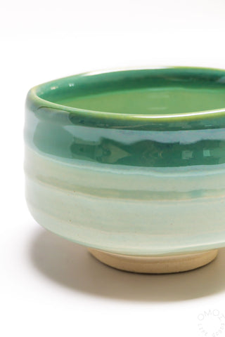 Seafoam ceramic matcha bowl close-up with glossy green top and pale base