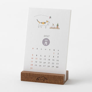 2027 cat stand desk calendar with illustrated cat scene, month wheel, and wooden base