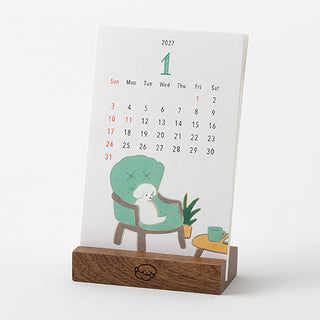 2027 desk calendar stand showing dog character on day 1, wooden base
