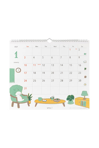 2027 wall calendar with monthly grid and illustrated dogs on desk scene