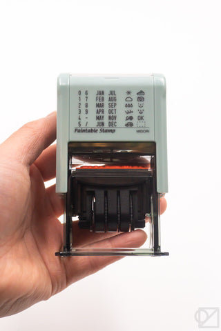 Mint date stamp tool held in hand, showing multiple stamp wheels and guide panel