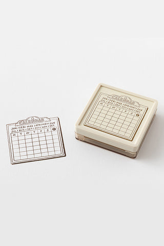 Paintable calendar block stamp with beige handle and small stamped calendar card