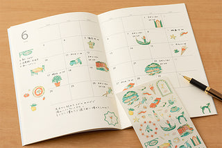 Opened notebook calendar with stickers spread across the page