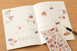 Open notebook calendar with stickers spread throughout