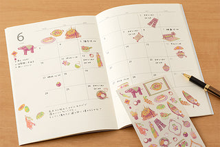 Open notebook calendar with stickers on the page