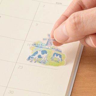 Hand placing sticker on a calendar