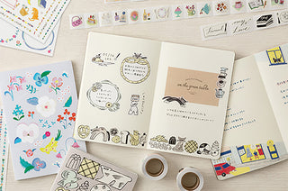 B6 dot grid notebook open to illustrated pages with animal and sweets drawings