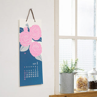 2027 floral calendar hanging on wall with pink peony artwork and date grid