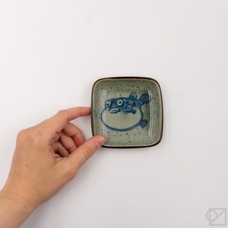 Small square ceramic puffer-fish dish with blue fish face print and dark rim