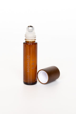 Brown rollerball skin scent bottle on a white background