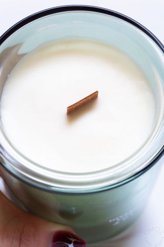 Close-up of a candle with wood wick n a glass container.