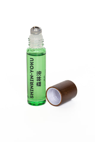 Green rollerball skin scent bottle with wooden cap on a white background