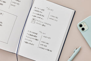 A5 hard cover dot grid notebook open to printed pages with table-style layout