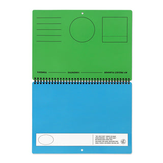 Green and blue spiral-bound planner calendar with shapes on a white background