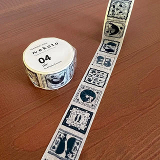 Roll of decorative tape with navy and white cat designs on a wooden surface