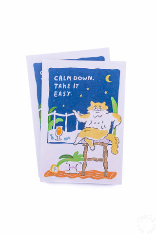 Card with a cat illustration sitting in a house setting that says 'Calm down, take it easy' on a white background