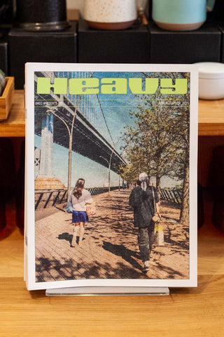 Travel magazine with illustrated city cover and people walking on a bridge
