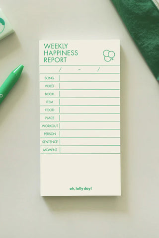 Notepad titled 'Weekly Happiness Report' with a green pen on a light surface
