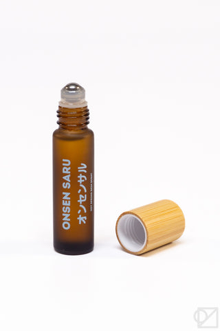Brown roller bottle skin scent with opened cap on a white background