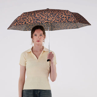 Person holding leopard print umbrella with wooden duck head handle opened over their head