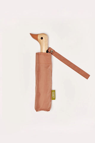 Mocha color umbrella with wooden duck head handle on a light background