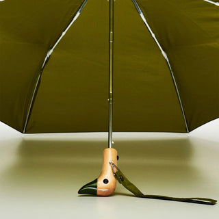 Green umbrella with a wooden duck handle on a light background
