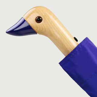 Blue umbrella with a wooden duck handle on a light gray background