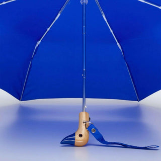 Blue umbrella with a wooden handle on a white background