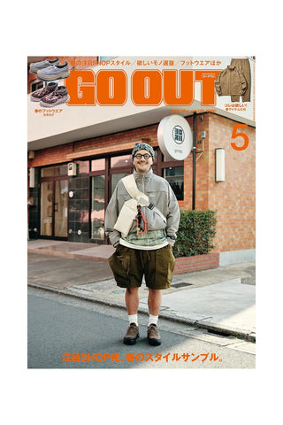 Magazine cover with a person standing on a street, featuring the 'GO OUT' magazine.