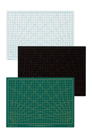 Three cutting mats stacked diagonally on a white background, each with a different color and grid pattern: a white mat with light blue lines, a black mat with orange lines, and a green mat with yellow lines.