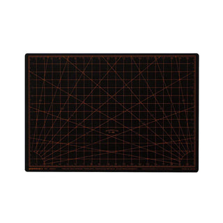 Black cutting mat with orange grid lines on a white background