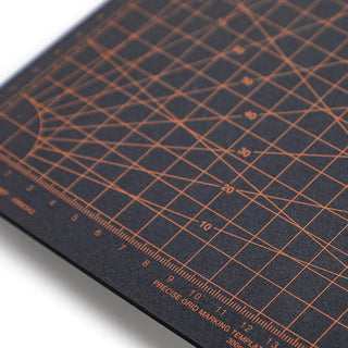 cutting mat with grid pattern with measurements on a black background