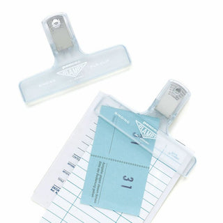 Two clear penco binder clips on a white background. One is holding receipts together