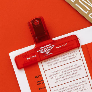 Red clip on a document on a red background